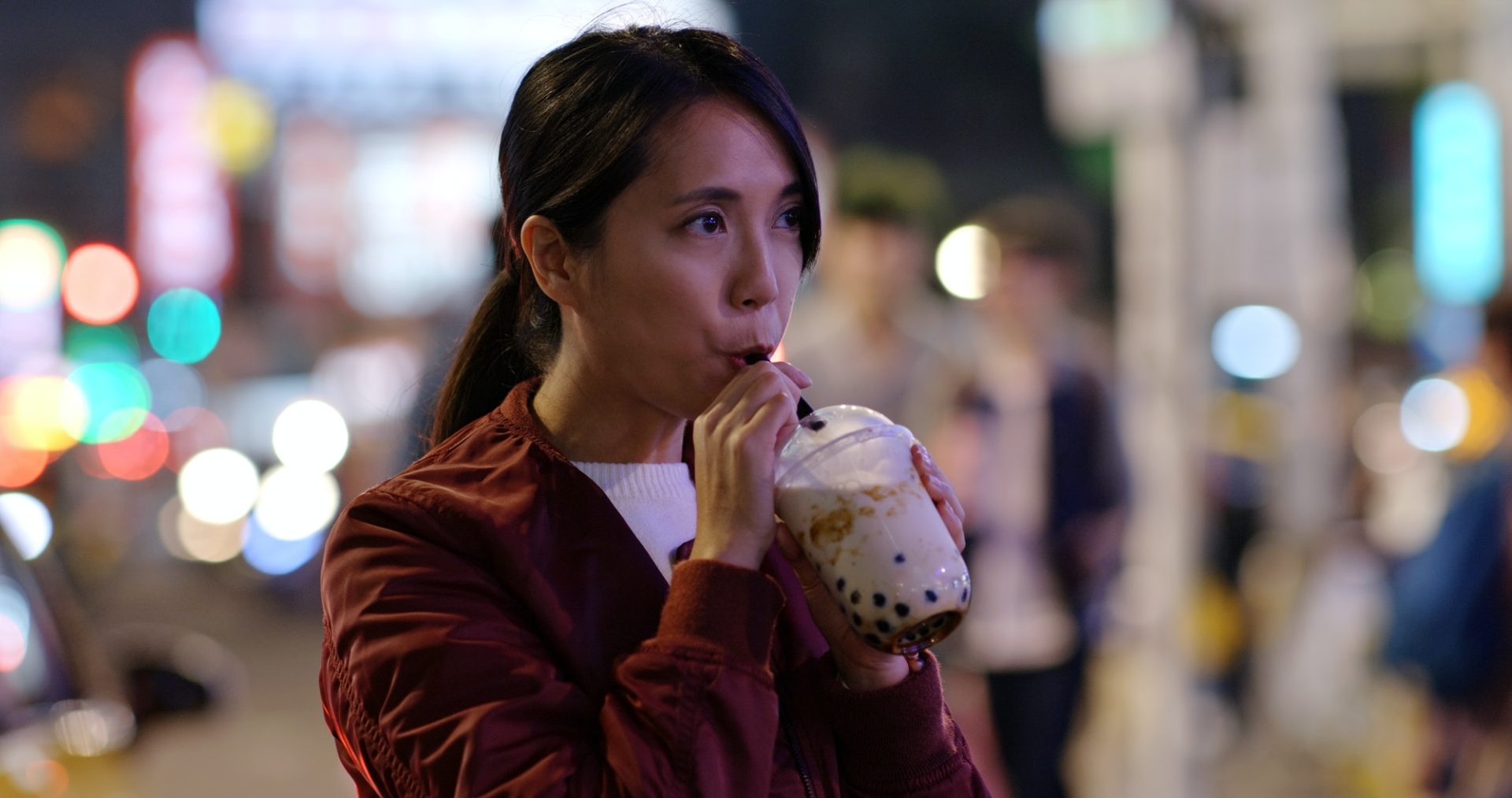 Woman drink of Taiwan iced bubble tea in the night market