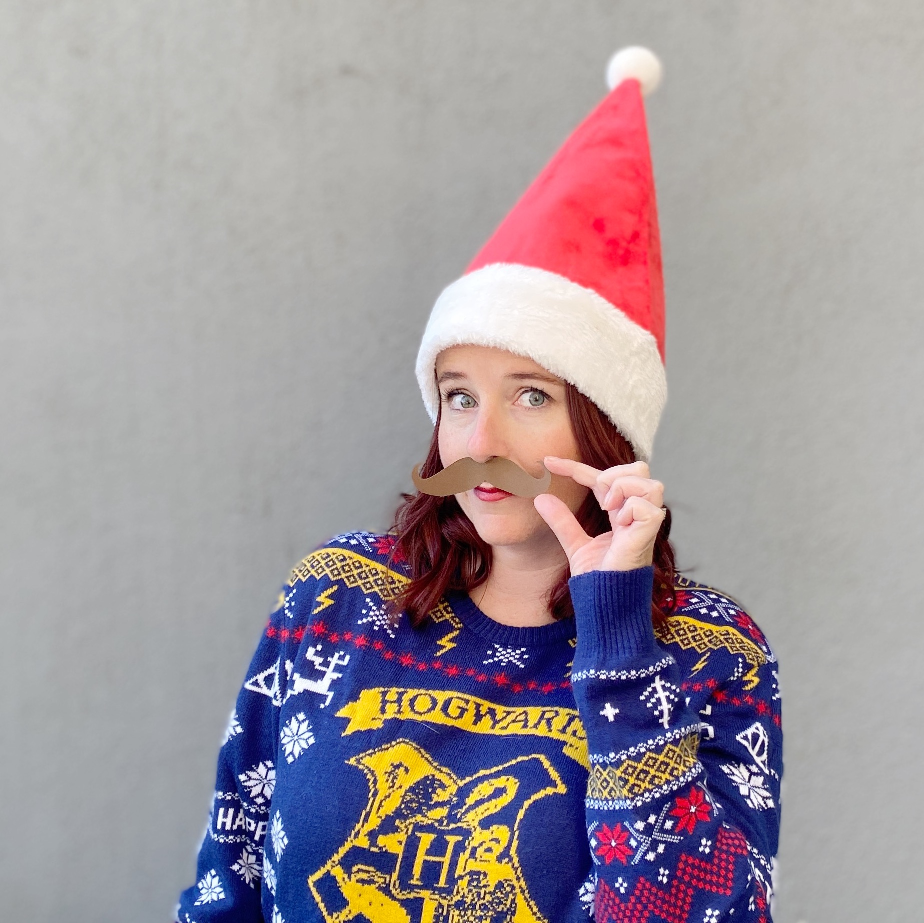 Woman in Santa hat posing with fake mustache