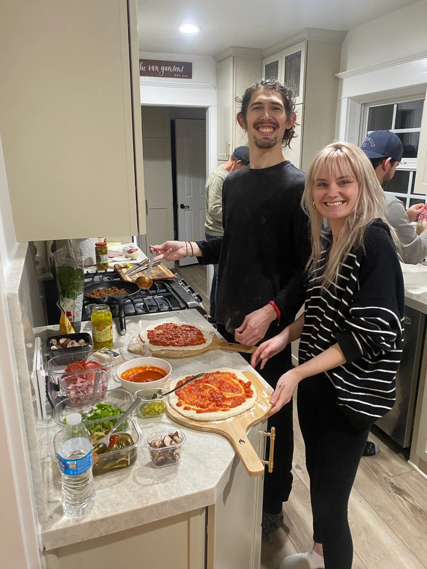Couple making homemade pizza in kitchen