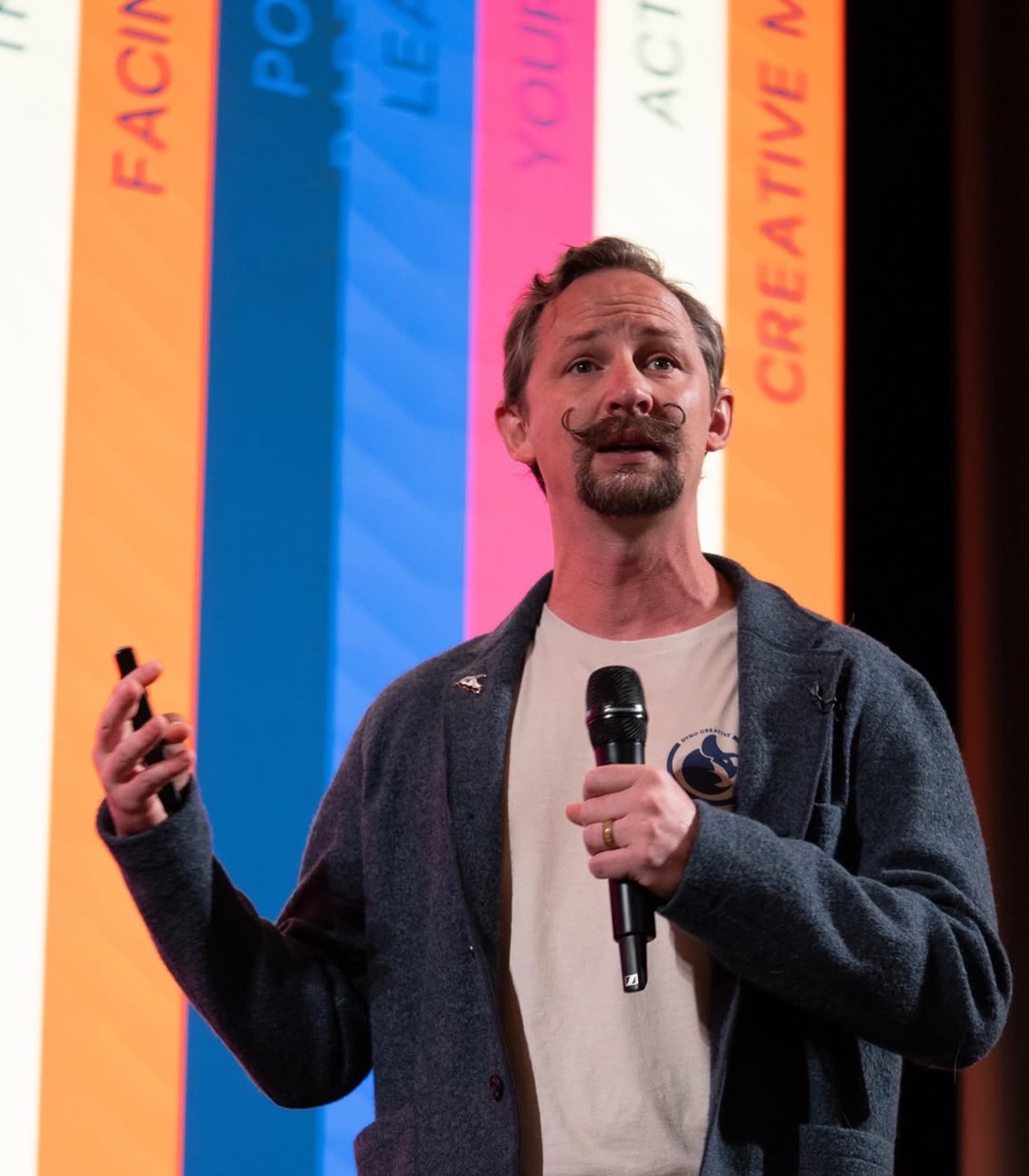 Man presenting at conference with colorful background