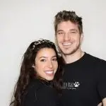 Smiling man and woman wearing matching black shirts