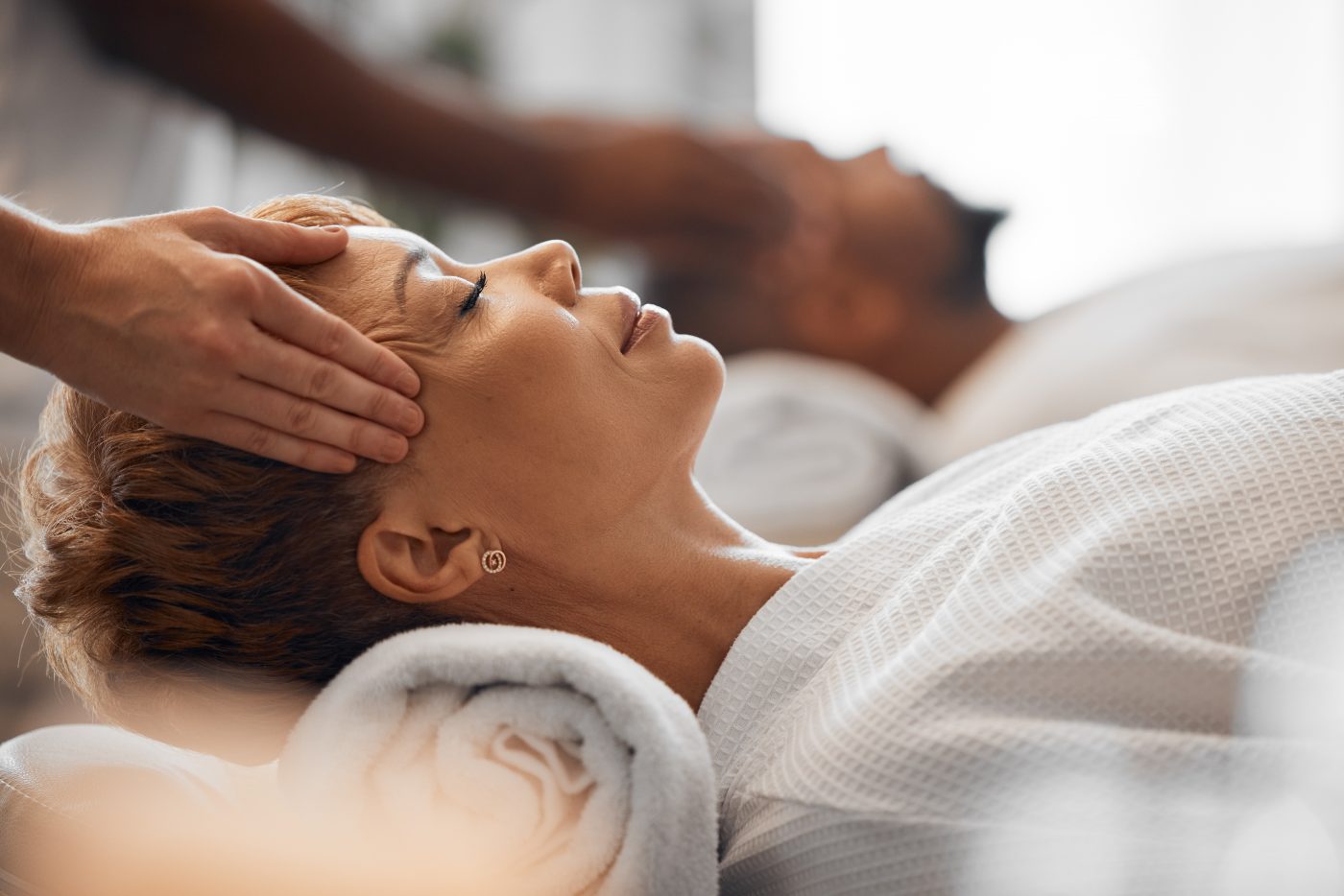 Woman receiving relaxing head massage in spa.